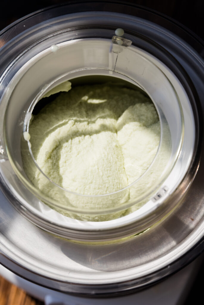 Thick, fluffy, mint ice cream churning in ice cream maker.