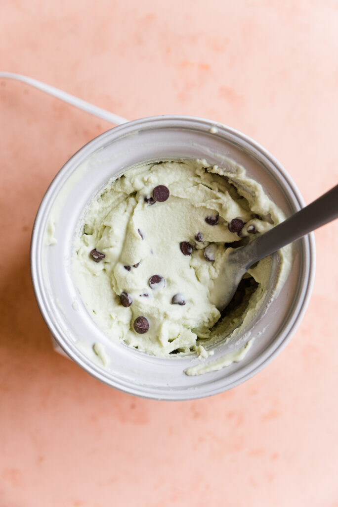 Creamy mint ice cream with chocolate chips in ice cream machine.