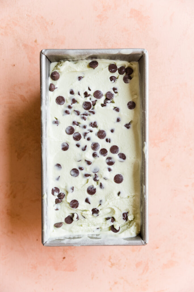 Dairy free mint chip ice cream spread into loaf pan.
