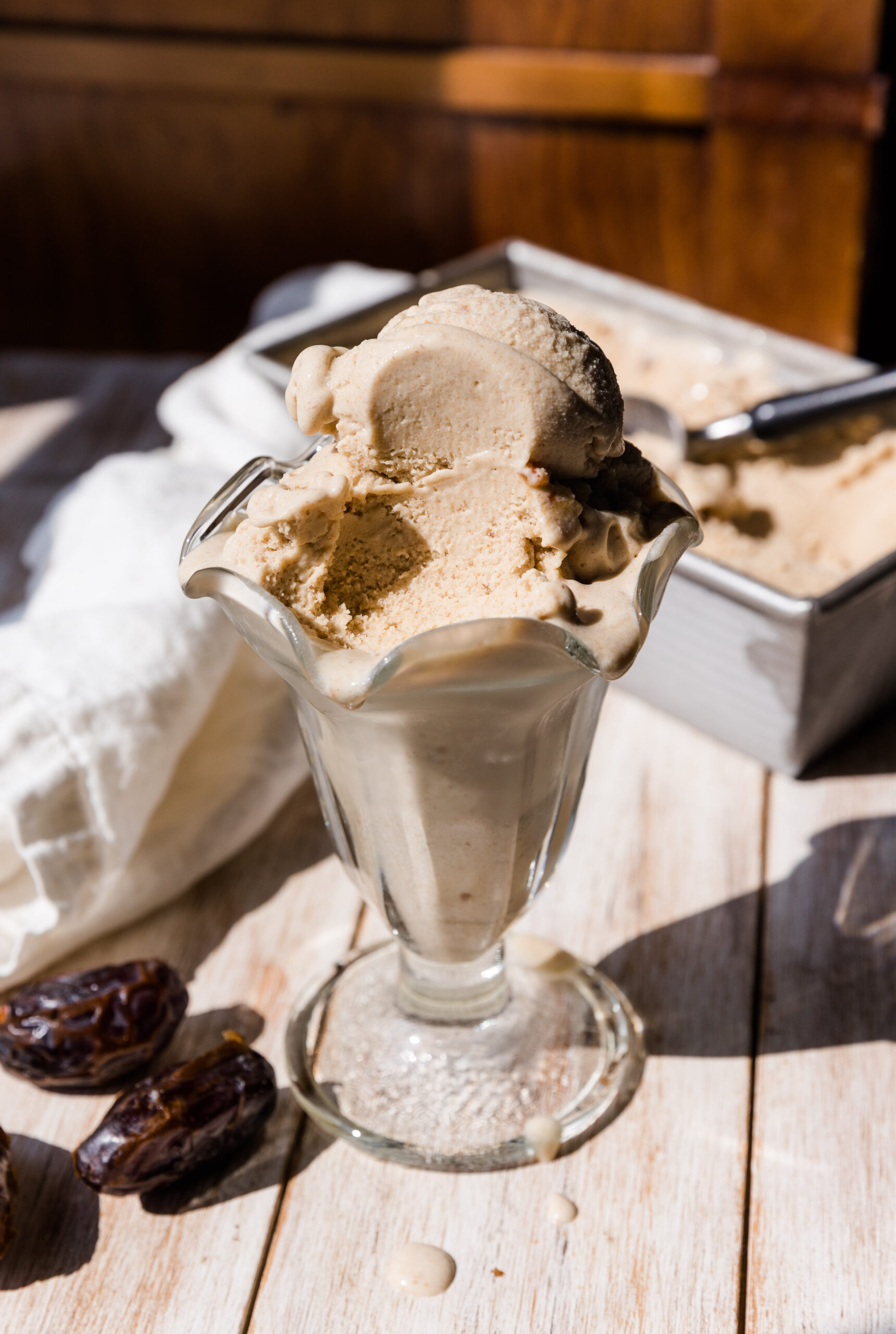 Salted caramel ice cream in a glass cup with a bite taken out.