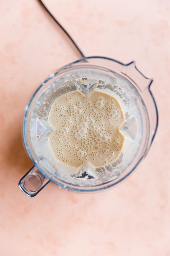 Creamy liquid ice cream mixture in blender.
