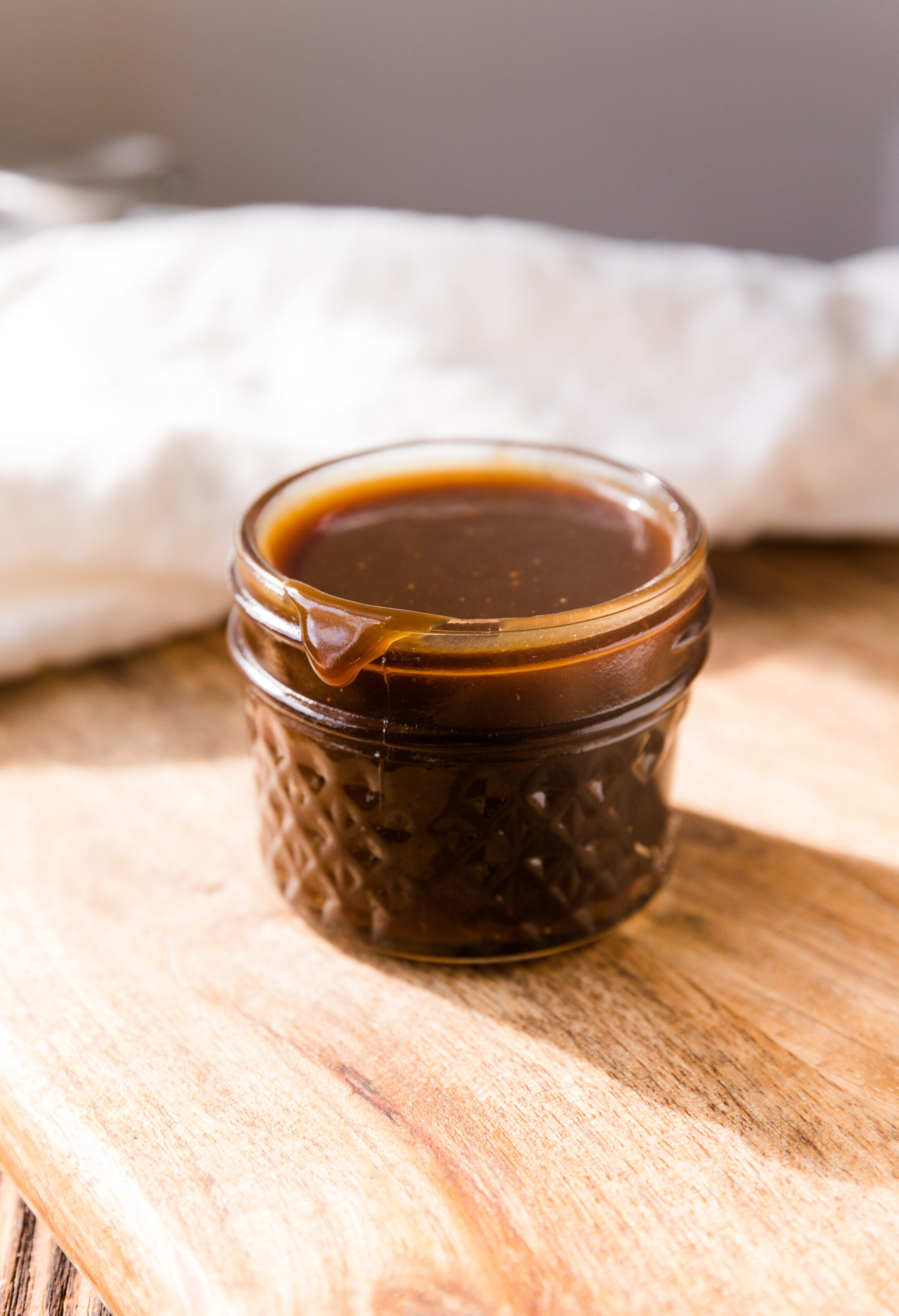 Dairy free caramel in small glass jar.