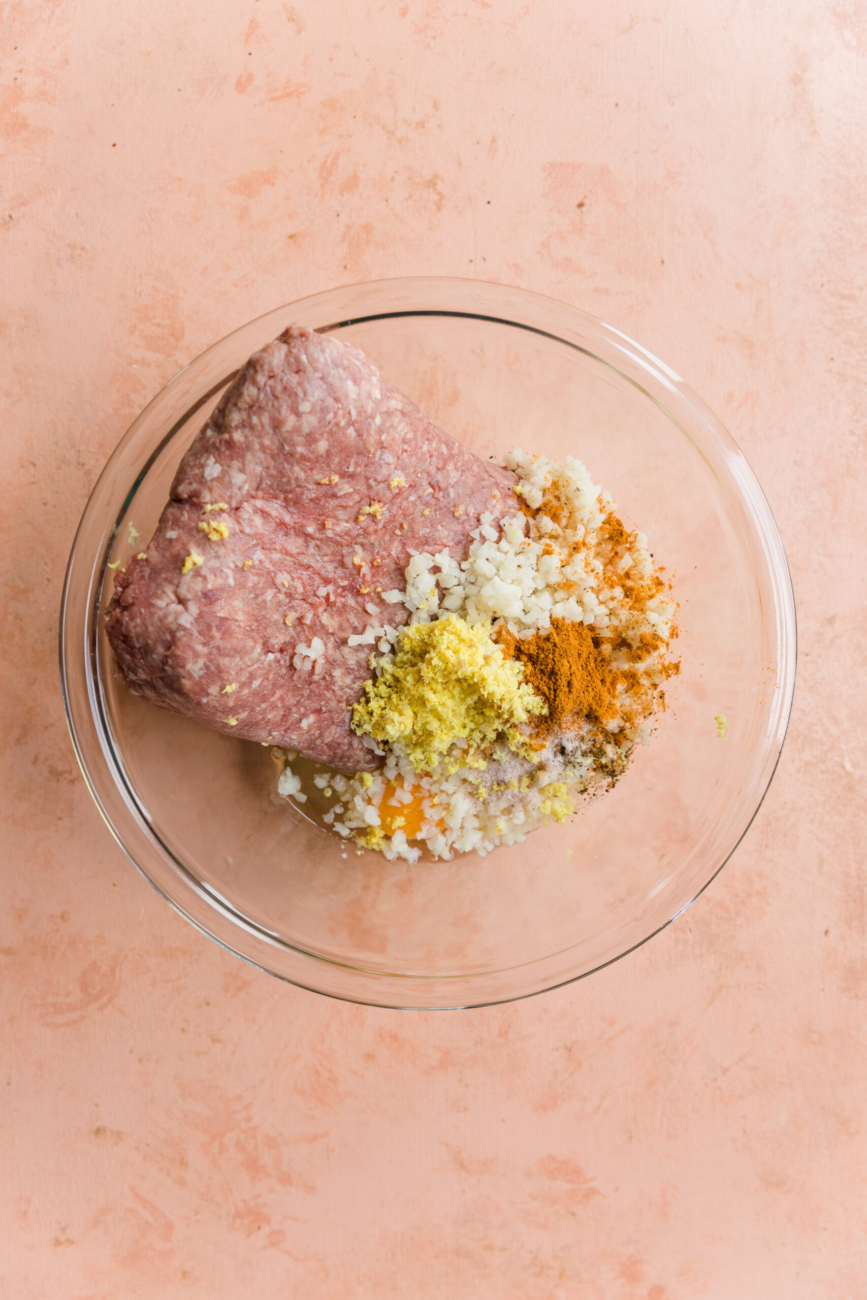 Ingredients for ginger curry meatballs in glass mixing bowl.
