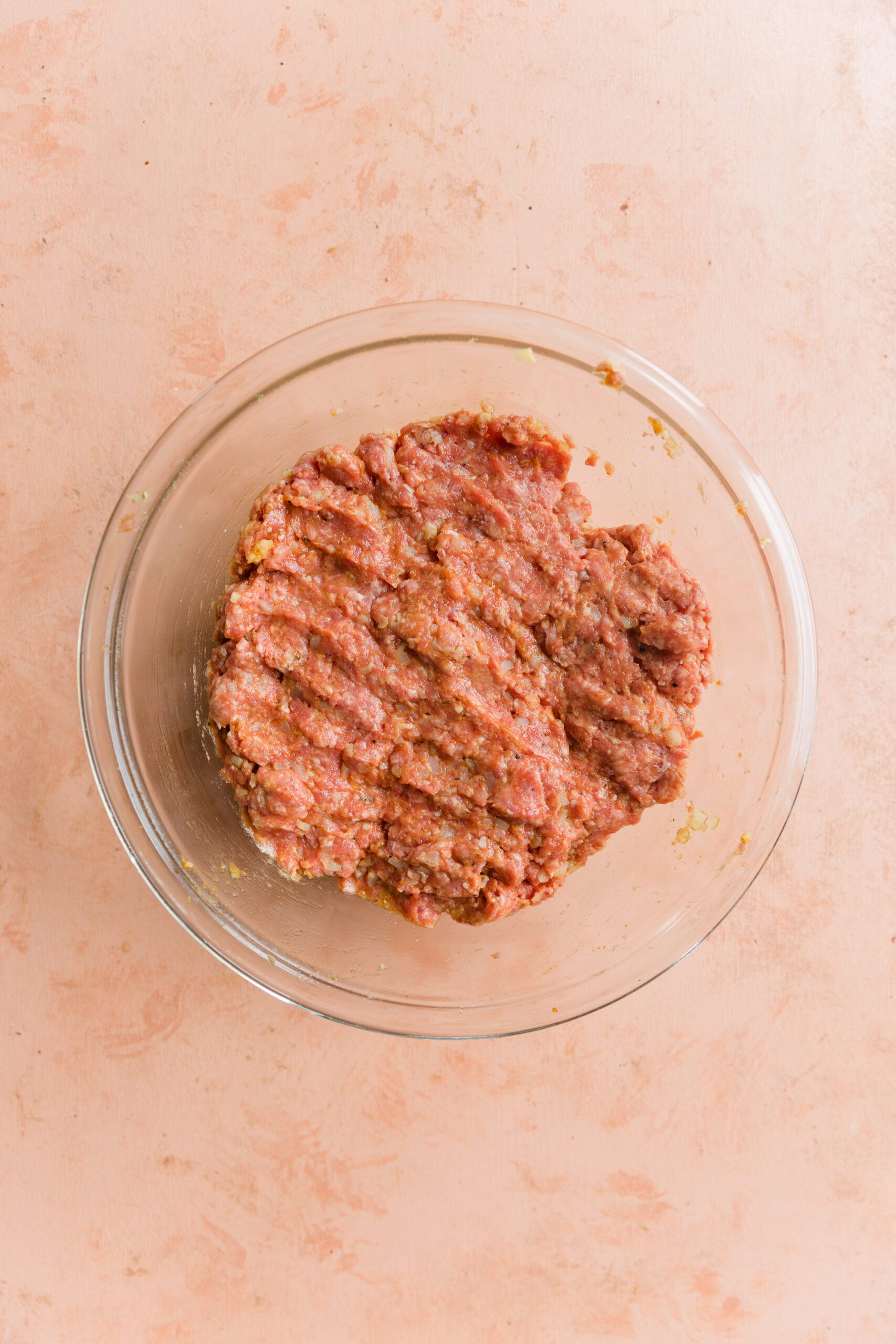 Ginger curry meatball mixture in glass mixing bowl.
