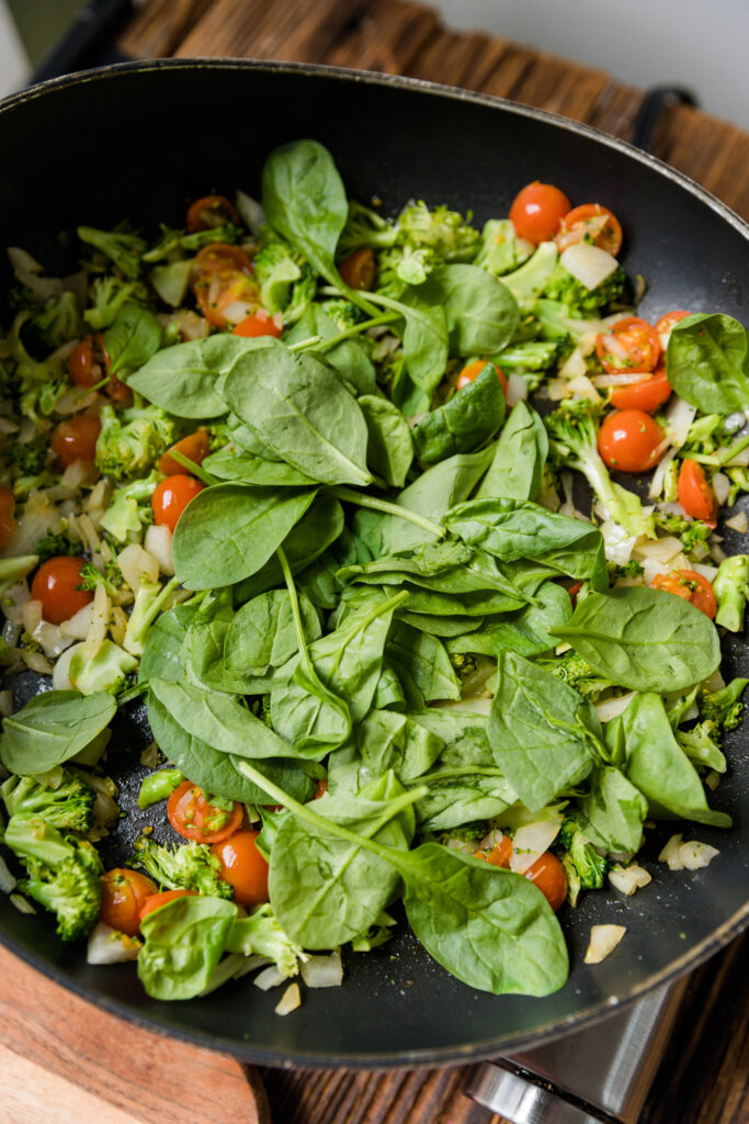 Spinach added to cooked vegetables.