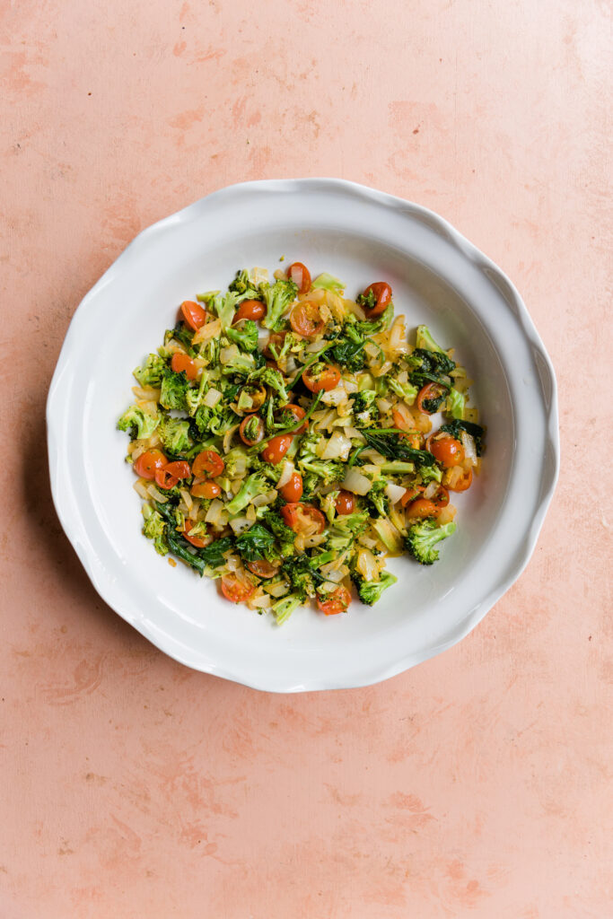 Cooked vegetables in round pie dish.