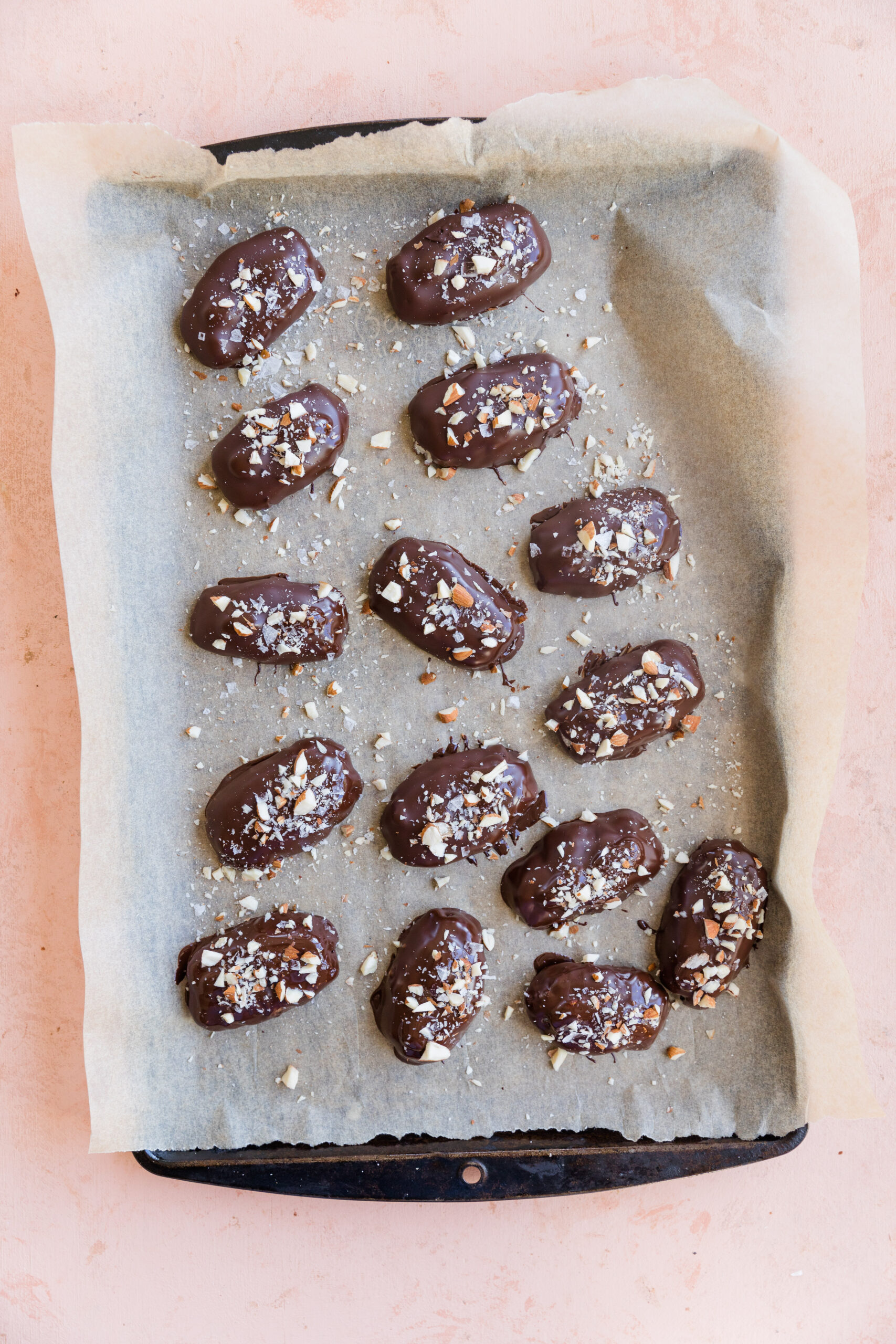 Almond joy candy bars coated in chocolate with chopped almonds on top.