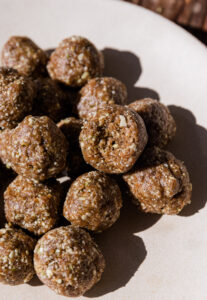 No Bake cinnamon energy balls stacked on top of each other with a bite taken out of one.
