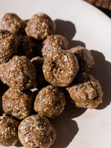 No Bake cinnamon energy balls stacked on top of each other with a bite taken out of one.