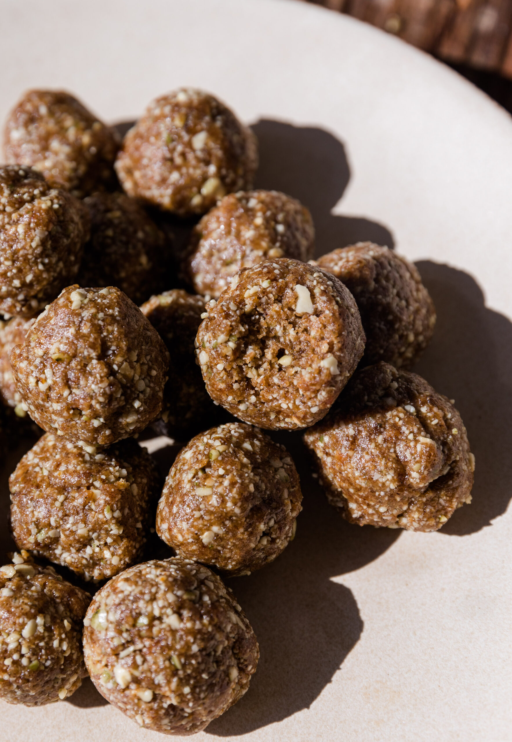 No Bake cinnamon energy balls stacked on top of each other with a bite taken out of one.