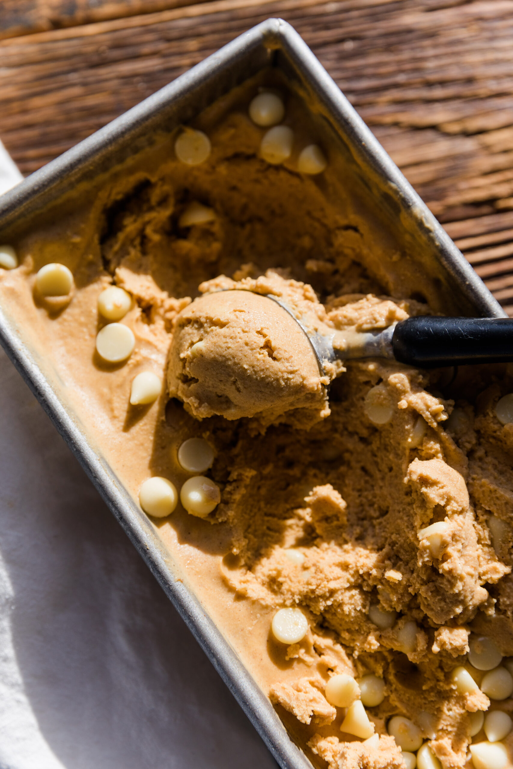 Pumpkin Ice Cream being scooped out of metal bread pan.