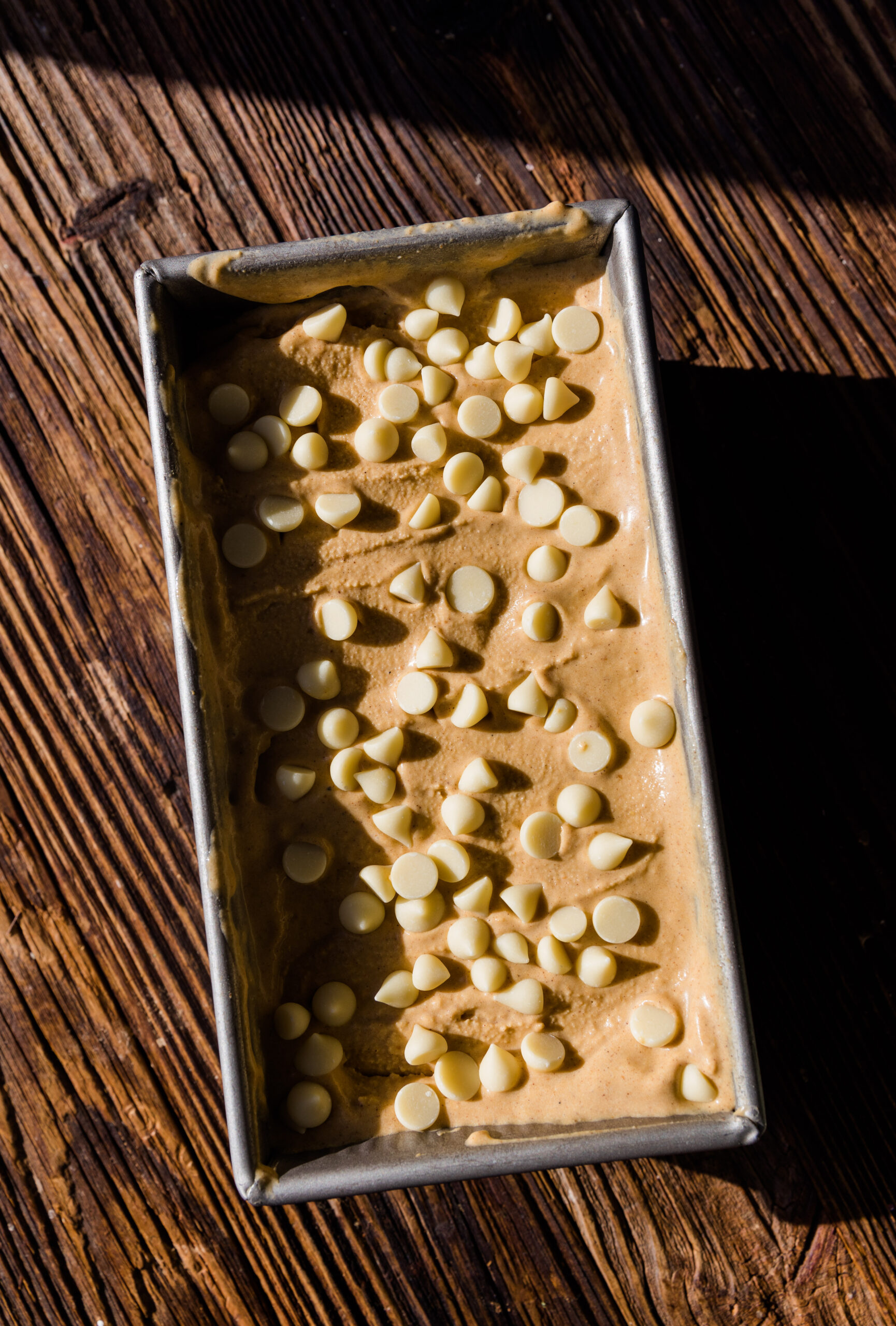 Vegan pumpkin ice cream in a metal loaf pan.