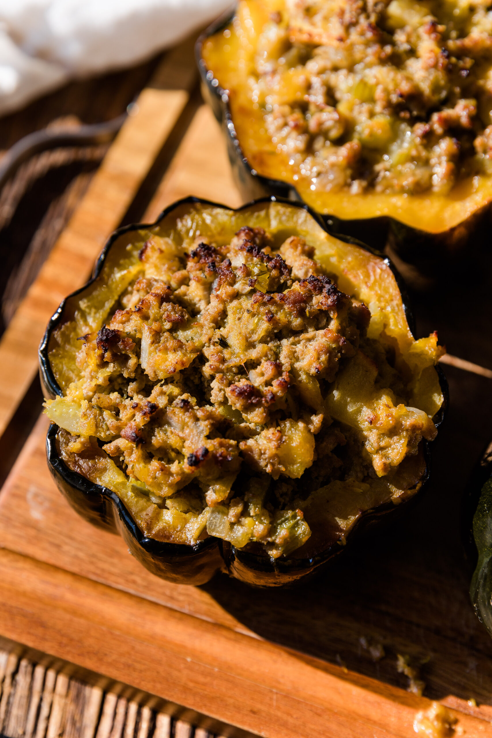 Stuffed acorn squash on a wooden board.