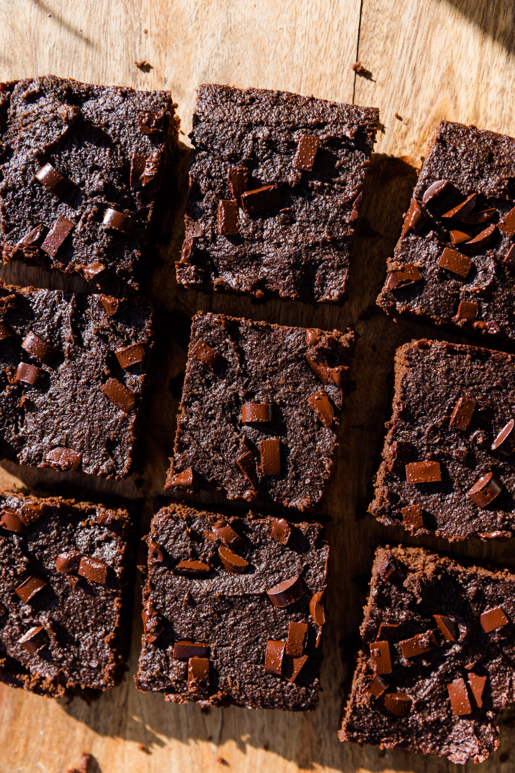 Almond flour brownies on a wood board with chocolate chips.