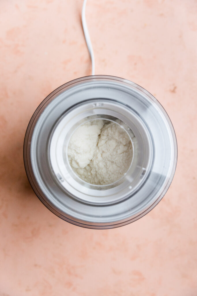 Thick peppermint ice cream churning in ice cream maker.