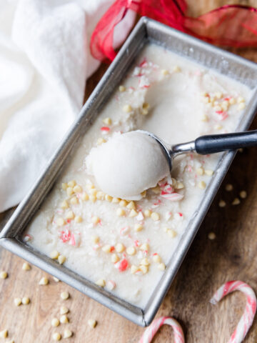 Peppermint ice cream being scooped out of a container.