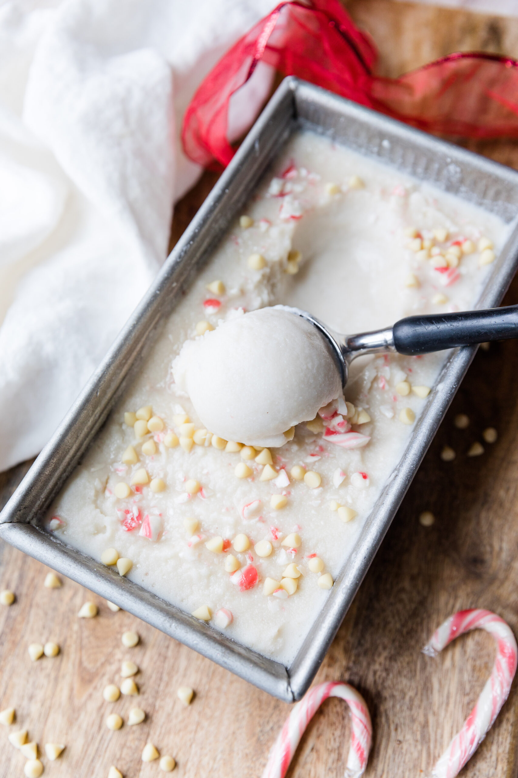 Peppermint ice cream being scooped out of a container.