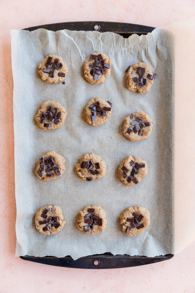 Chocolate chip cookies on parchment paper lined baking sheet.