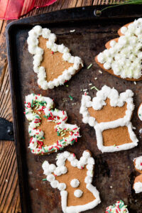 Gluten-Free cut out sugar cookies with white frosting and green and red sprinkles.