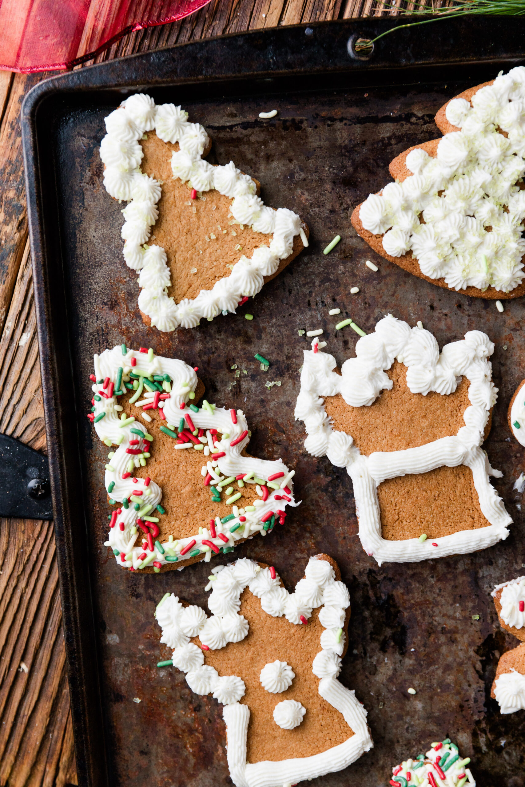 Gluten-Free cut out sugar cookies with white frosting and green and red sprinkles.