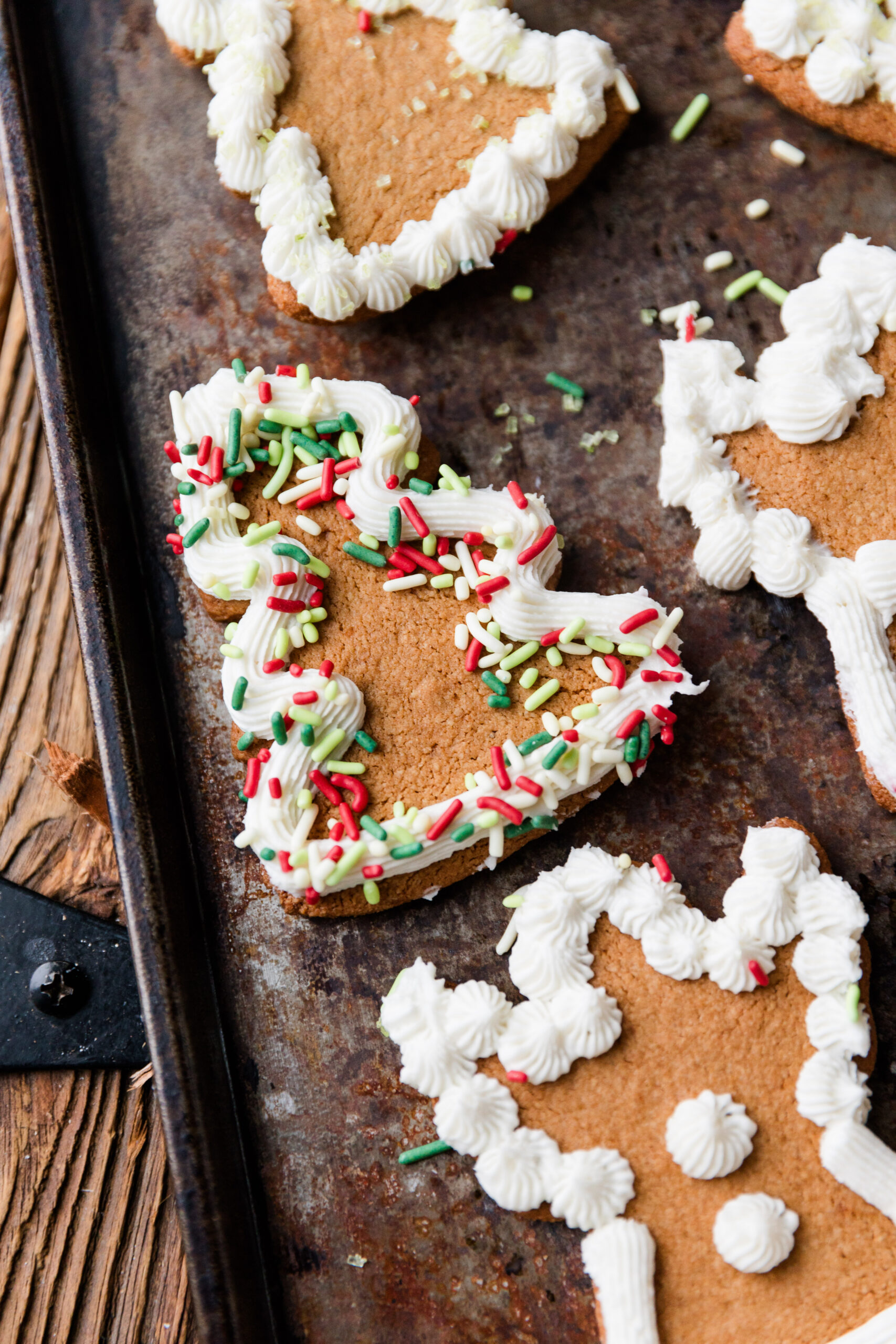 Gluten-Free cut out sugar cookies with white frosting and green and red sprinkles.
