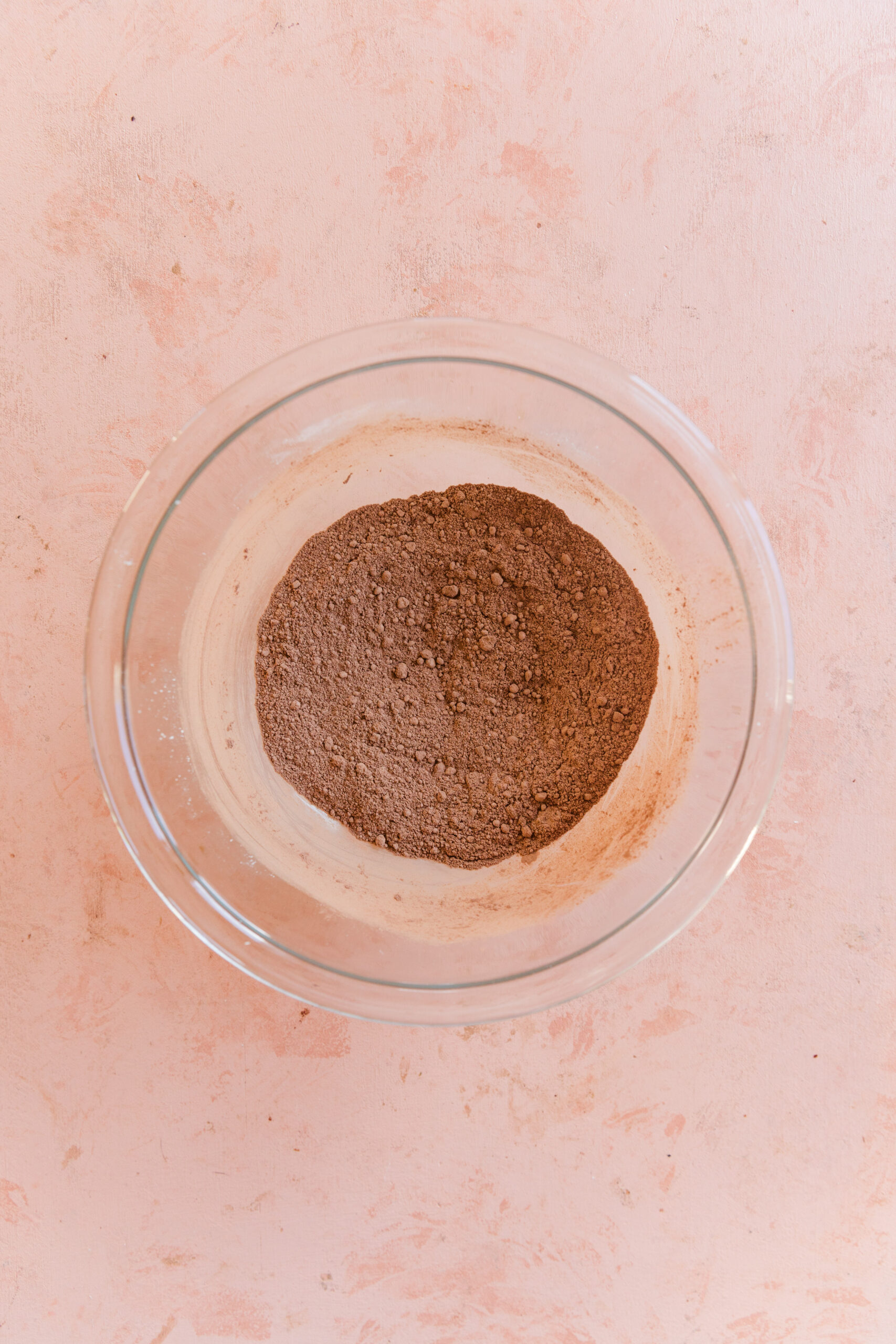 Dry ingredients for gluten free chocolate cupcakes in a glass mixing bowl.