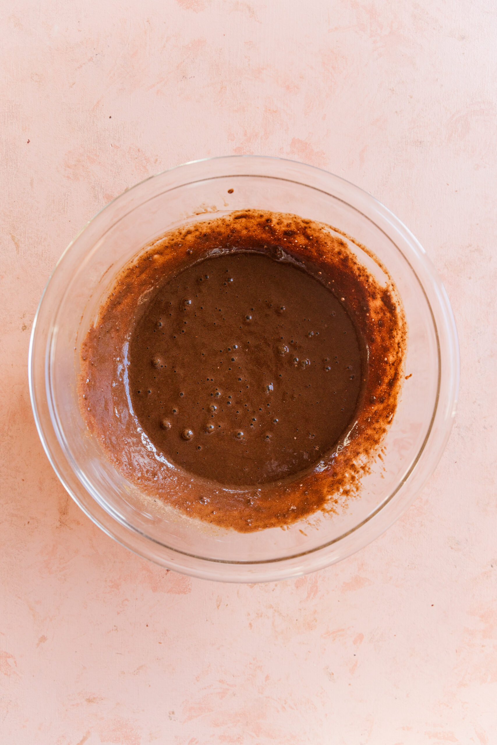 Chocolate cupcake batter in glass mixing bowl.
