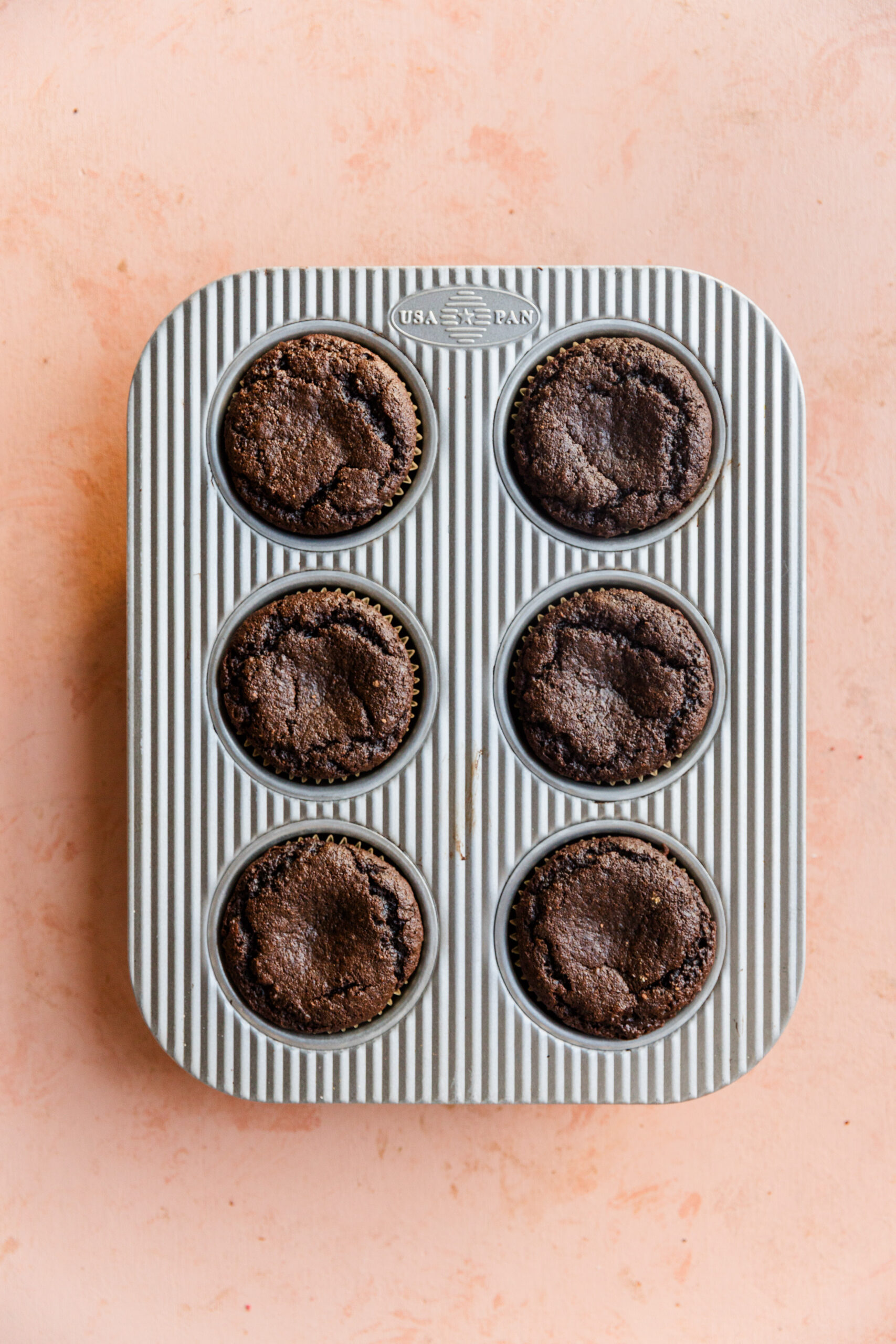 Baked chocolate cupcakes in baking tin.